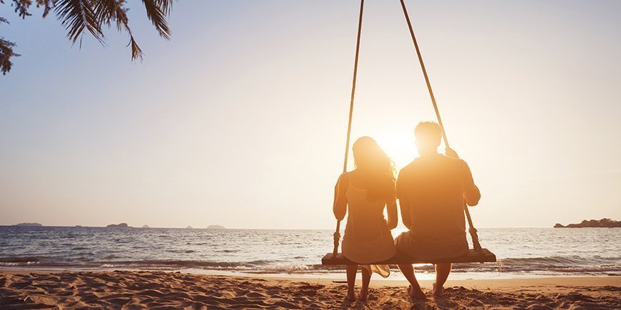 Honeymoon travel, silhouete of couple in love on the beach.